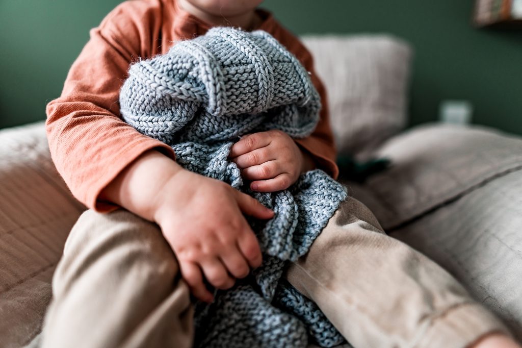 young child holding special blanket