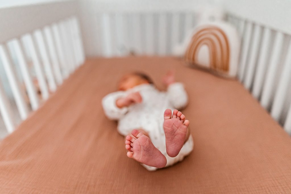Newborn baby feet in crib