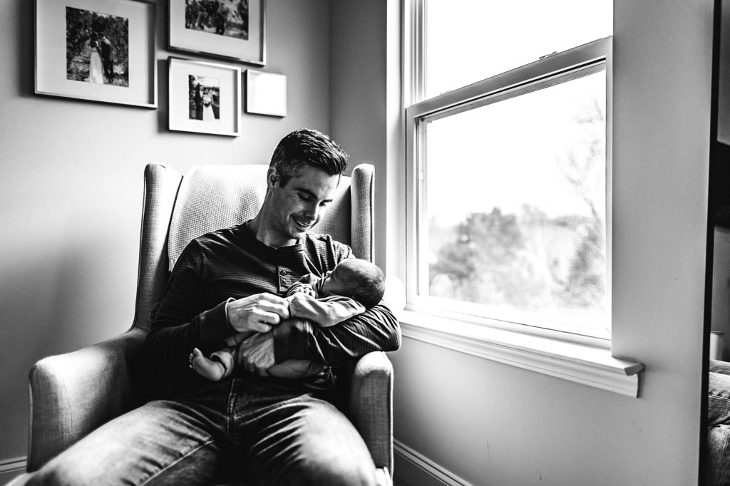 Father holds newborn daughter black and white